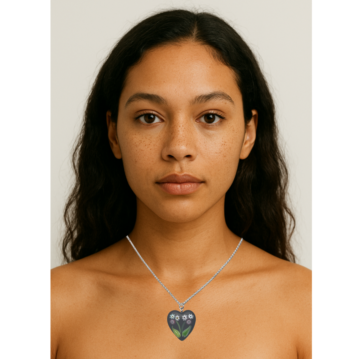 Woman wearing a necklace with a heart-shaped pendant on a plain background