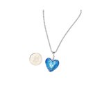 a small aqua heart shaped necklace next to a coin