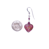 a pair of earrings with a pink heart and a coin