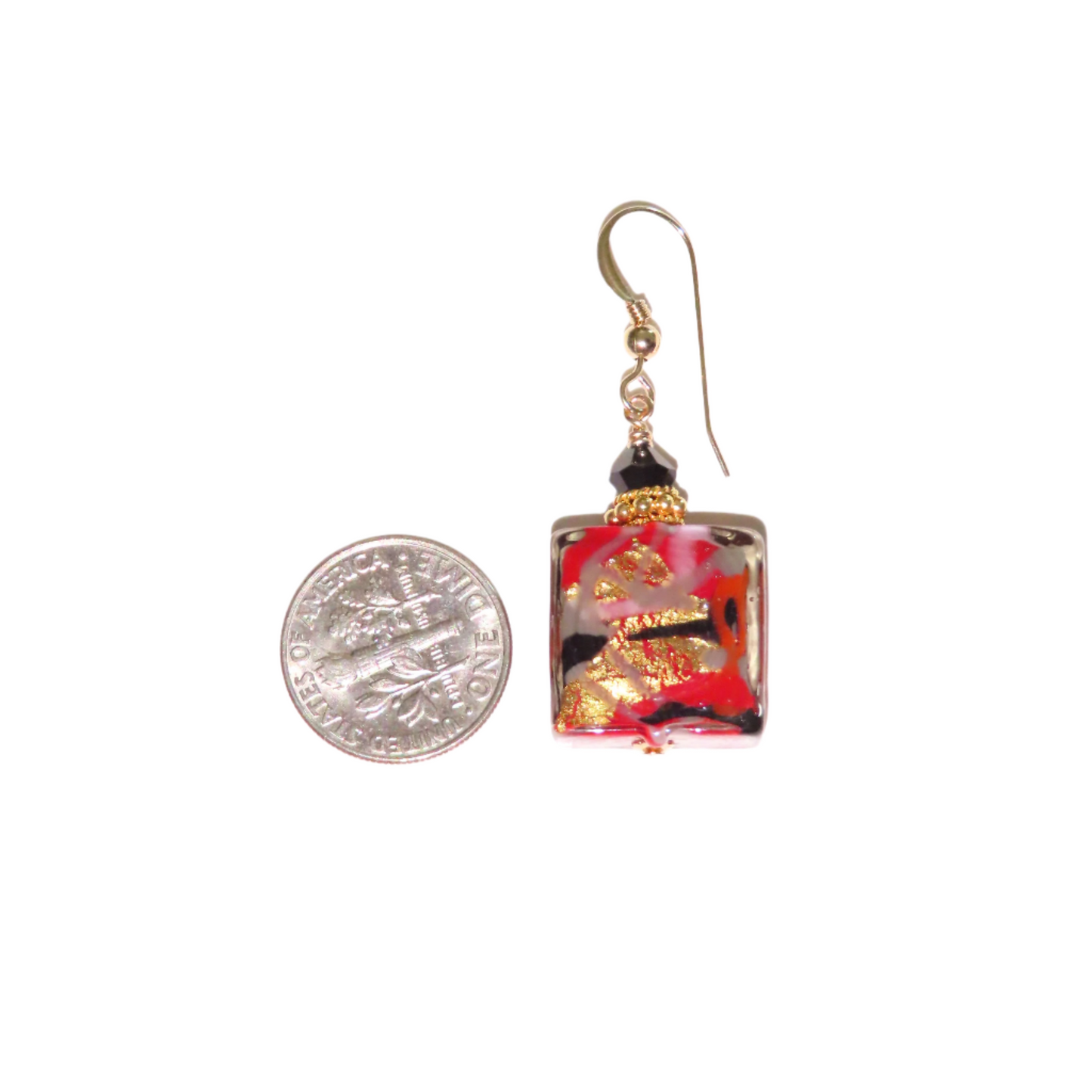 a pair of earrings sitting next to a coin