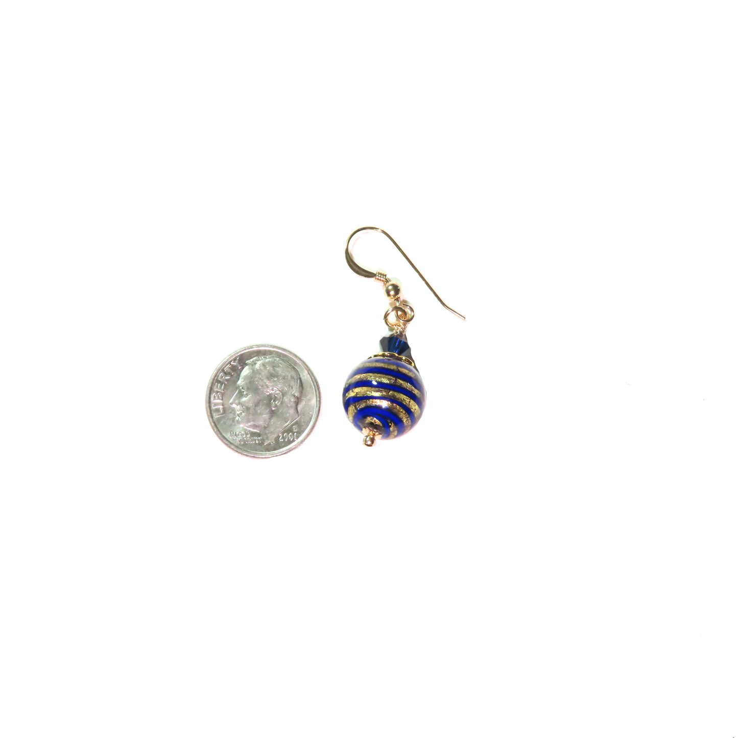 a pair of earrings sitting next to a coin