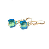 a pair of blue and green earrings on a white background