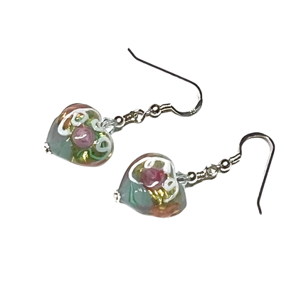 Heart-shaped glass earrings with floral design on a white background