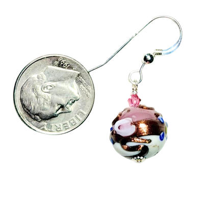 Small decorative ball with a pink rose design on a white background, next to a dime for scale.