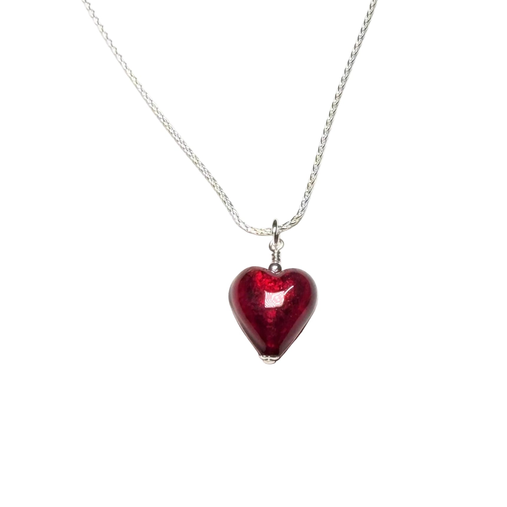 Red heart-shaped pendant on a silver chain against a white background