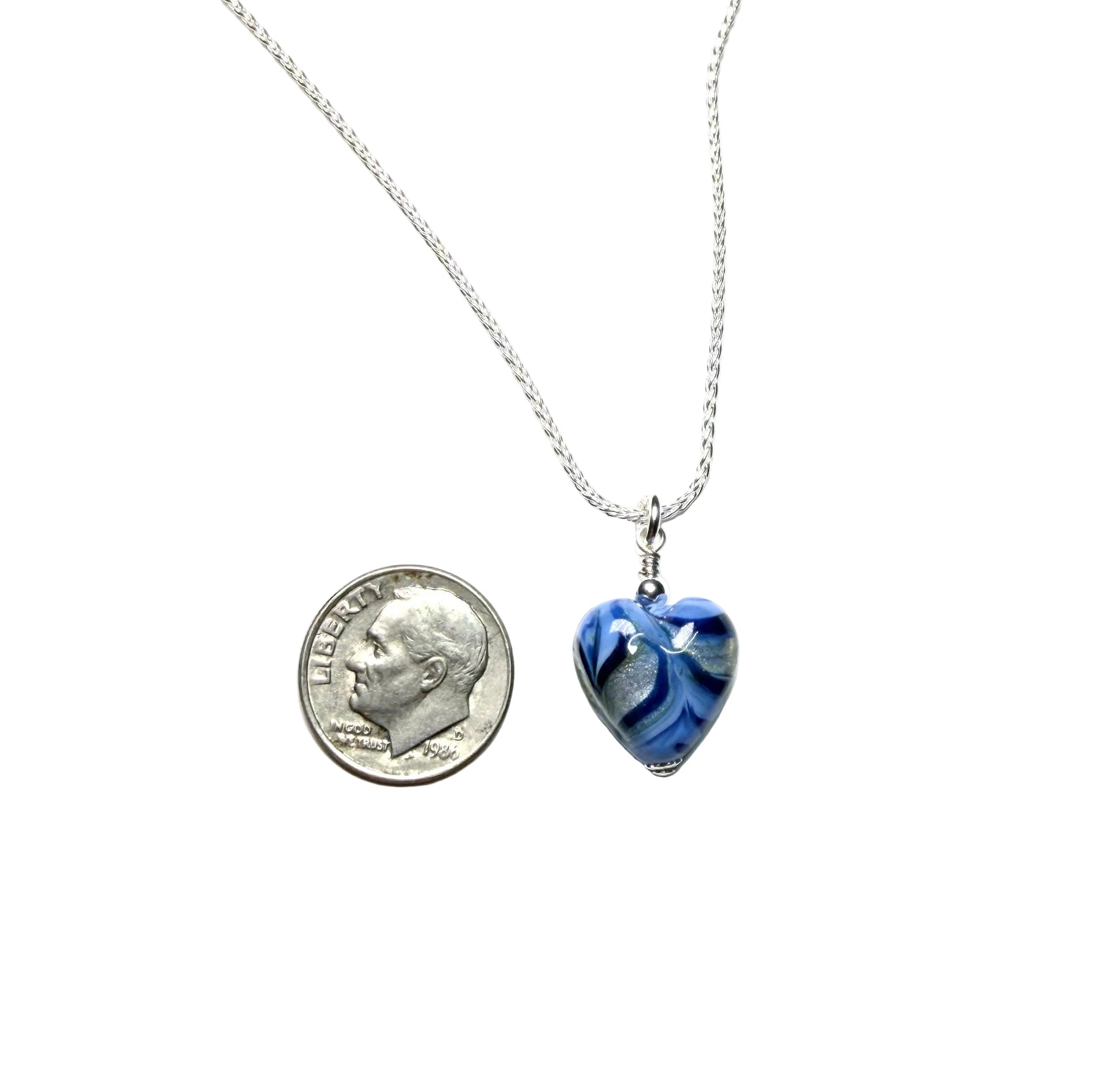 Blue heart-shaped pendant on a silver chain with a dime for scale on a white background