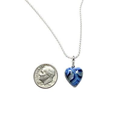 Blue heart-shaped pendant on a silver chain with a dime for scale on a white background