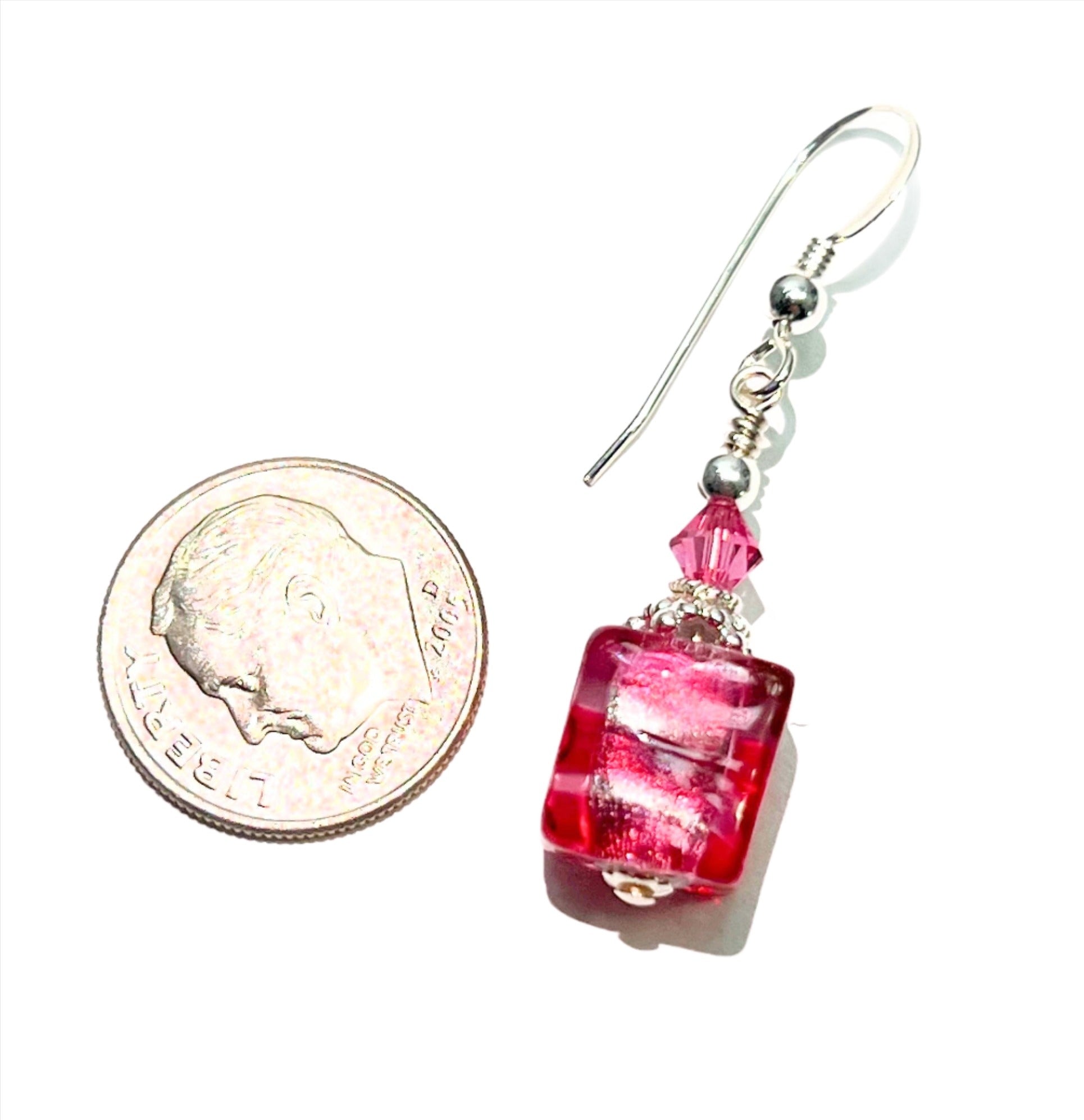a penny and a pair of earrings on a white surface