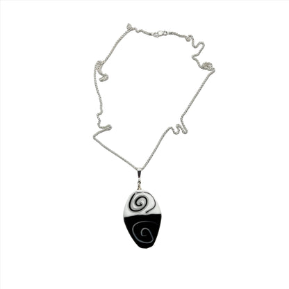 a black and white necklace with a spiral design