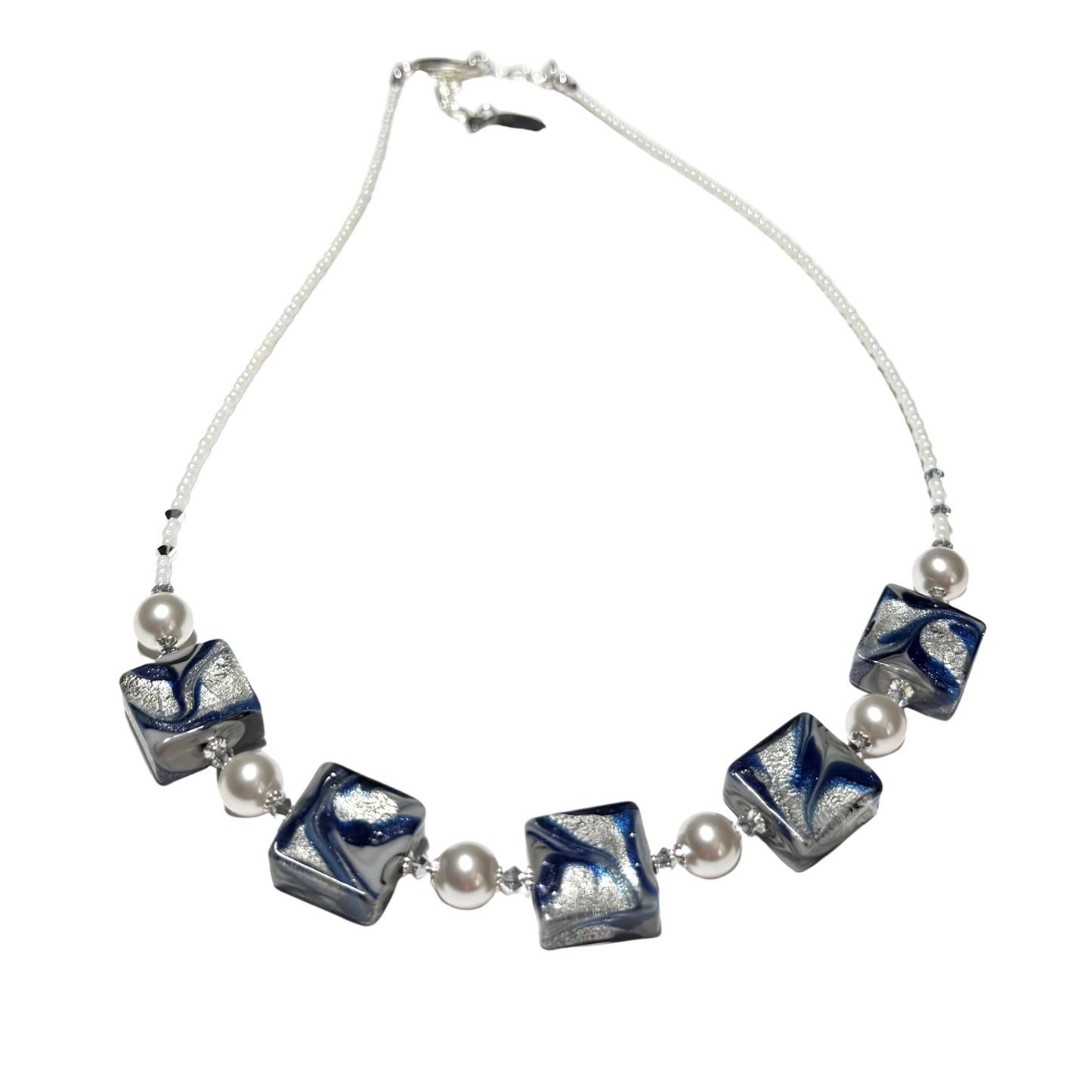 A Murano glass beaded necklace featuring five square glass beads with a blue, white, and gray swirled pattern, separated by small white pearl-like beads on a white cord, shown against a plain white background.