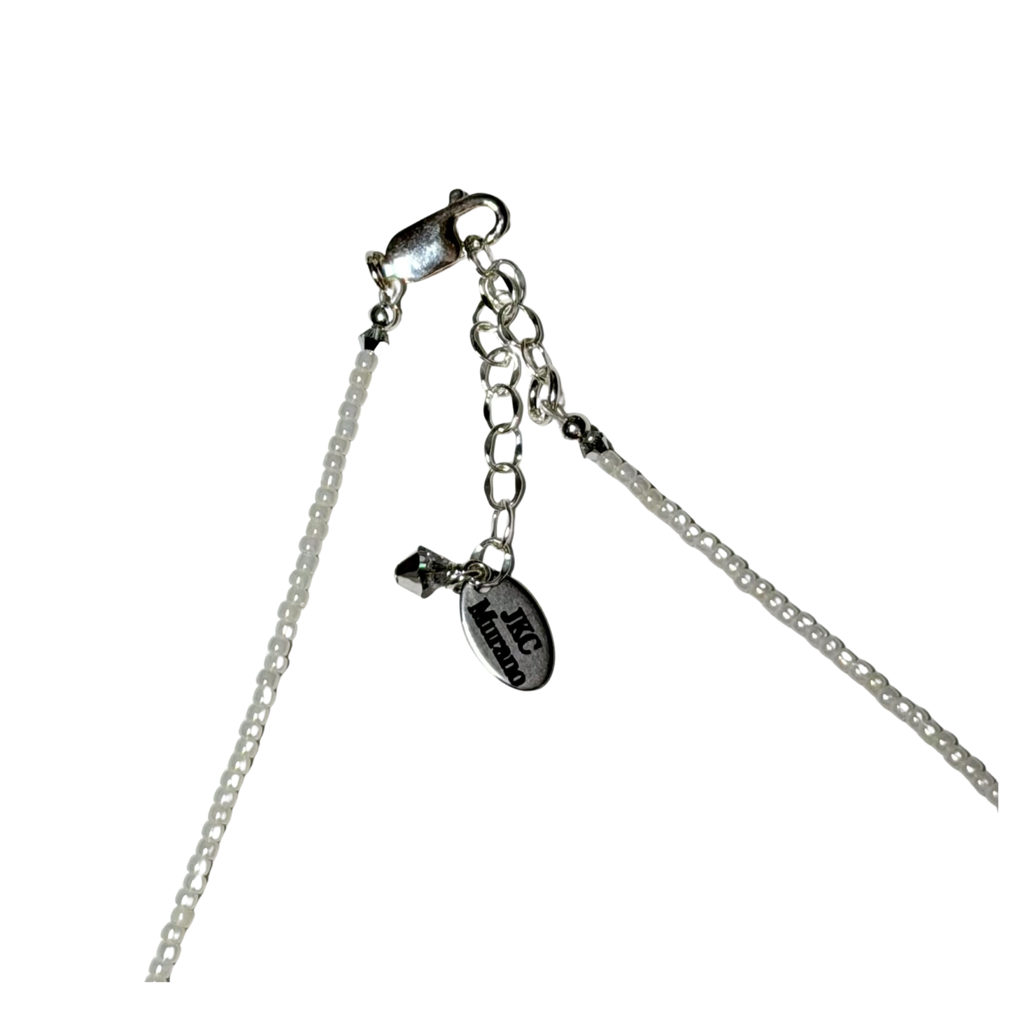 Silver chain necklace extender with lobster clasp, short chain links, and a small oval charm engraved with JKC and 'Murano' on a white background.