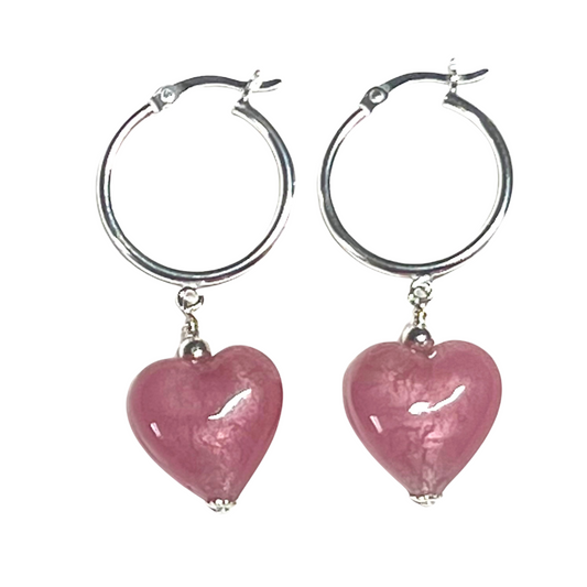 Silver hoop earrings with pink heart-shaped beads on a white background