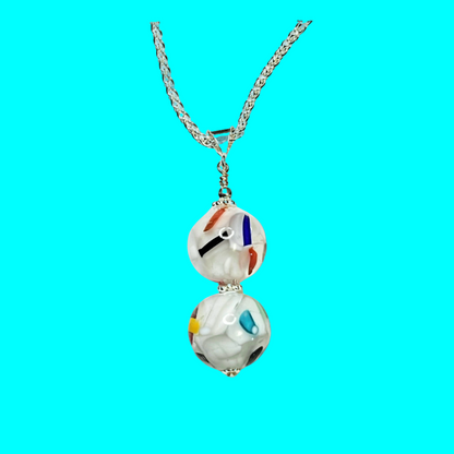a couple of necklaces sitting on top of a white surface