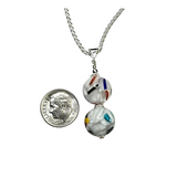 a coin is next to a necklace with beads on it