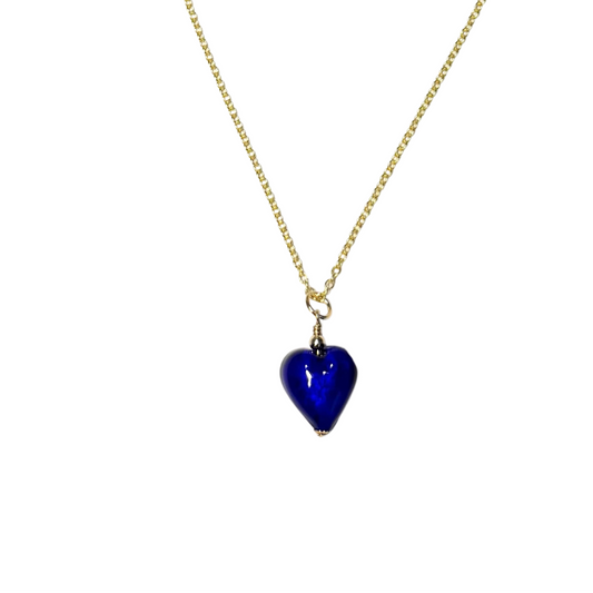 A delicate gold chain necklace featuring a small, faceted cobalt blue heart pendant, displayed against a solid white background.