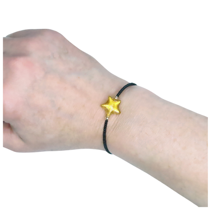 a person wearing a bracelet with a star on it