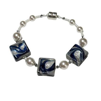 A beaded bracelet featuring three square glass beads with a blue and silver swirl pattern, separated by white faux pearls on a silver chain with a silver clasp.