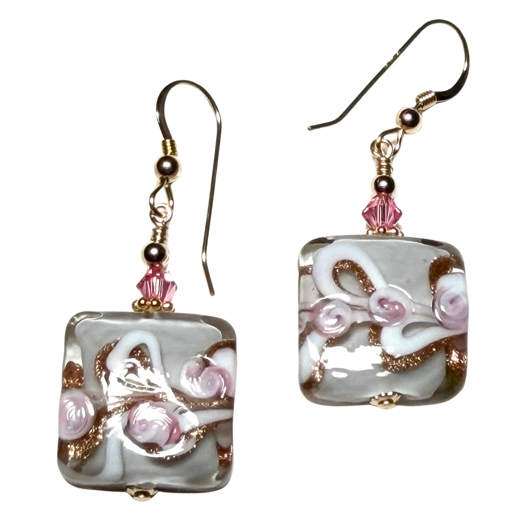 Pair of square-shaped earrings with floral design on a white background