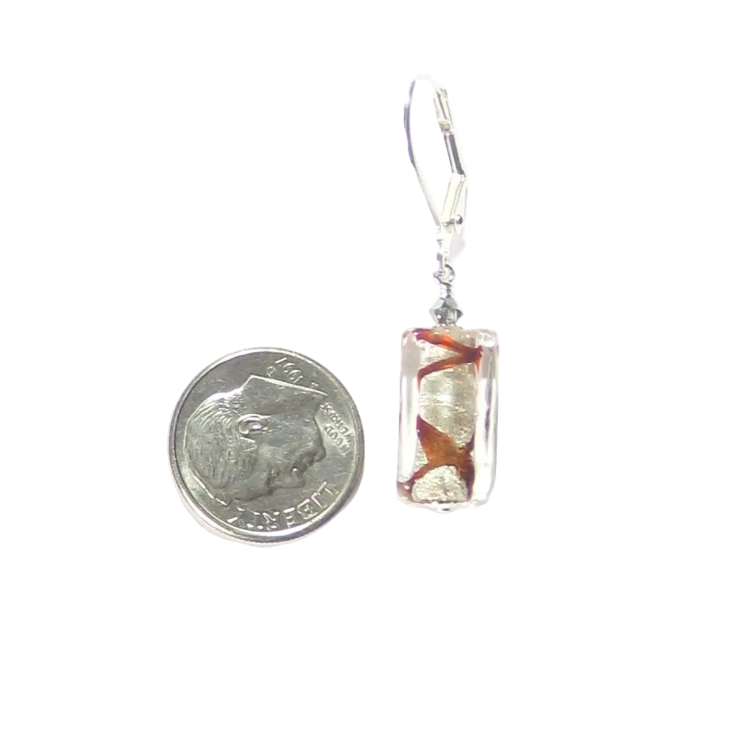 Small rectangular earring with floral design next to a quarter on a white background