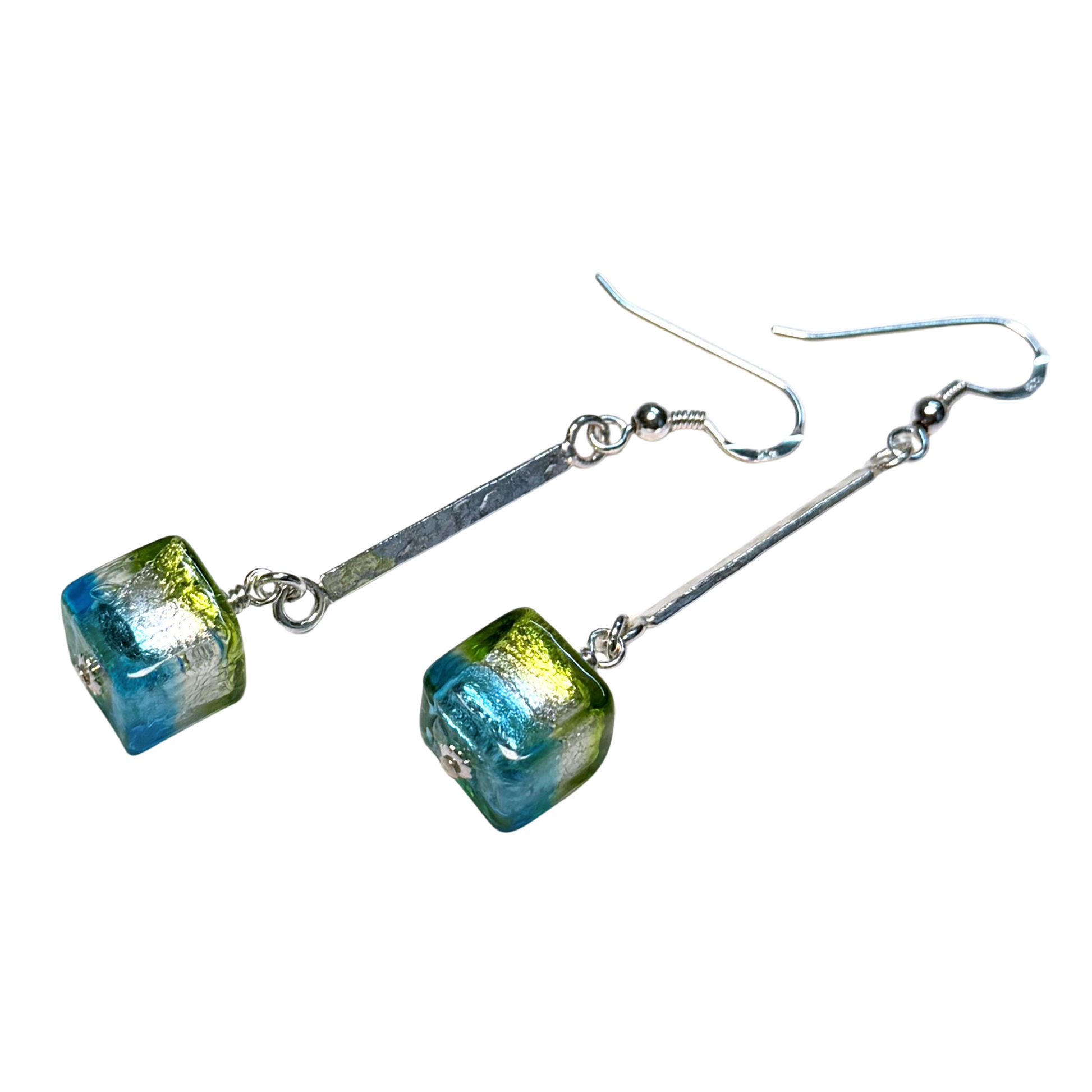 A pair of drop earrings featuring cube glass beads with a blue and green  pattern, suspended from sterling silver metal bars and fishhook wires, shown against a plain white background.
