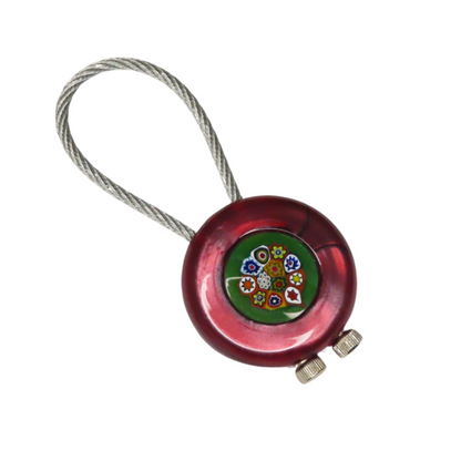 Red metal keychain with floral design on a white background