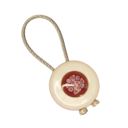 Round beige device with floral design on a white background