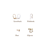 four different types of earrings on a white background