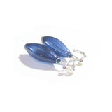 a pair of blue glass earrings sitting on top of a white surface