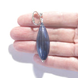 a person is holding a small blue pendant