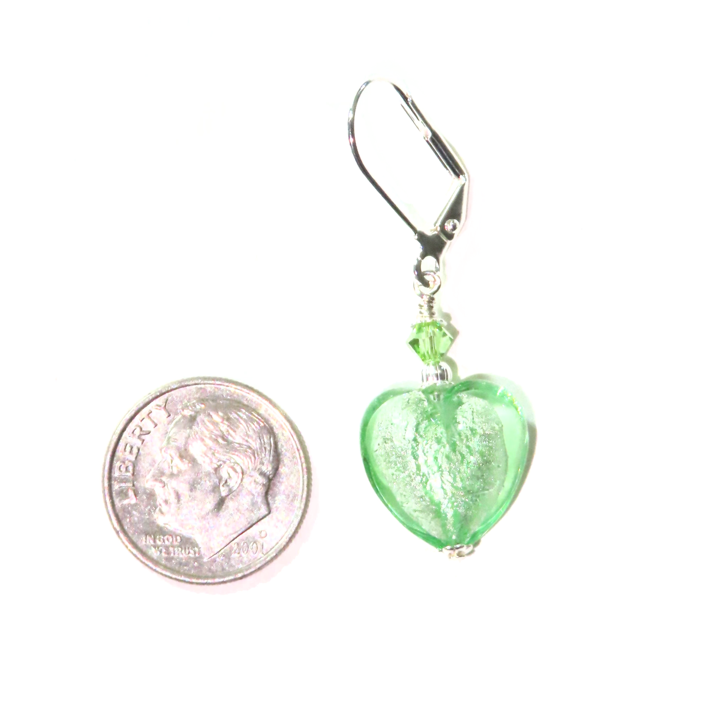 a small green heart shaped glass bead hangs from a hook