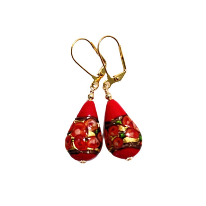 a pair of red and gold earrings on a white background