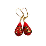 a pair of red and gold earrings on a white background