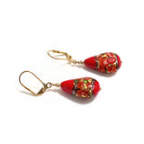 a pair of red earrings with gold hooks